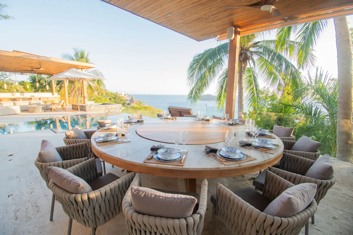 Comedor exterior de una villa privada con vista al mar